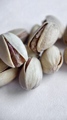 Close-up of Cracked Pistachios Revealing Texture and Color on a Light Background