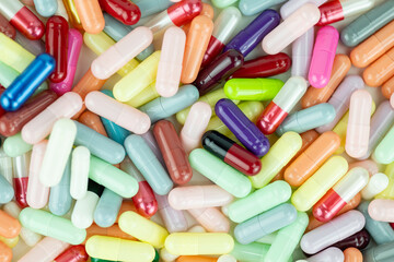 Variety of colorful medical capsules and pills in a full frame close-up, representing pharmacy and health.