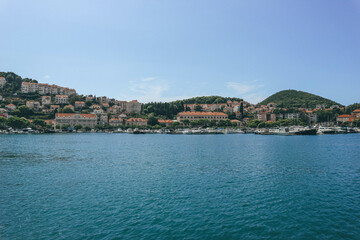Fototapeta premium town of dubrovnik by the sea boats in the bay of lovely beautiful blue waters mediterranean sea croatian coast town