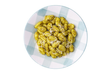 Italian pasta gnocchi on a plate with pesto sauce and parmesan cheese isolated over white background