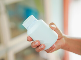 Close up hand holding medicine bottle in home care for concept healthcare wellness health or healthy lifestyle people. Person using drugs or antibiotics for treatment. Female Elderly care. Medical 