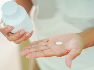 Senior Asian woman holding drugs for concept healthcare and medical. Close up hand medicine bottle with pill at home care for healthy lifestyle people wellness health. Elderly care female patient 