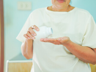 Senior Asian woman holding drugs for concept healthcare and medical. Close up hand medicine bottle with pill at home care for healthy lifestyle people wellness health. Elderly care female patient 