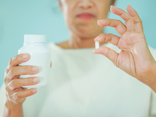 Senior Asian woman holding drugs for concept healthcare and medical. Close up hand medicine bottle with pill at home care for healthy lifestyle people wellness health. Elderly care female patient 
