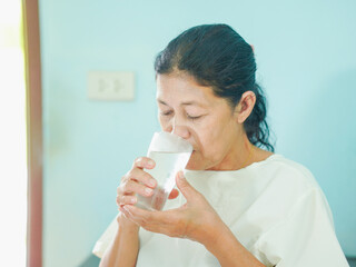 Senior Asian woman drinking water glass in morning, Healthy Lifestyle people for routine, nutrition, hydration body care and health care. Elderly care wellness health. Female beverage anti aging 