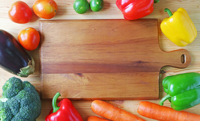 Frame of rainbow color assorted fresh vegetables on wooden background