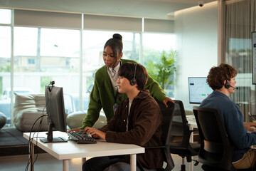 Team of tech savvy customer support professionals collaborates in modern office, using computers...