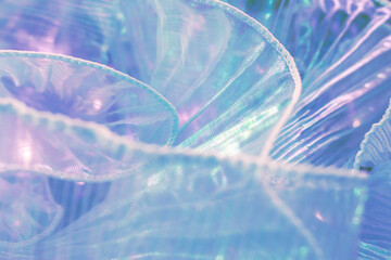 Close-up of iridescent translucent fabric in light blue and purple tones with wavy ruffled edges and shimmering reflections; ideal for fashion, textile branding, wellness, and artistic visuals