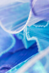 Close-Up of Layered Translucent Fabric in Blue and Purple – Soft Flowing Texture with Stitching...