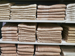Row of white towels are stacked on a shelf