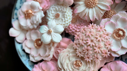 Sam Pan Nee, Thai dessert in pastel pink color tone with various flower shaped, Coconut milk flavor taste, Authentic Thai traditional handcraft snack in Dark background