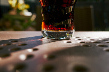 Glass of cola is sitting on a table