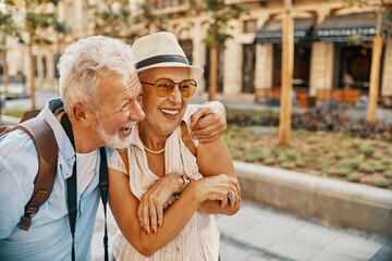 Happy senior couple sightseeing and laughing together in the city