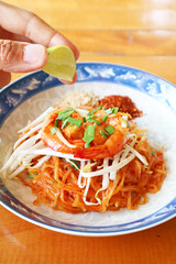 Squeezing Lime Juice into Freshly Cooked Pad Thai Noodle for Adding Tartness