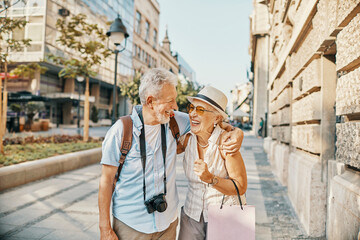 Happy senior couple sightseeing and laughing together in the city