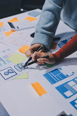 UX UI designer testing prototype on a phone, discussing and brainstorming on wireframes for a...