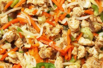 Asian stir fry with chicken and vegetables. Colorful mix of meat, carrots, onion and peppers. Tasty homemade meal. Healthy lunch or dinner. Close up of delicious food in wok. Balanced nutrition plate.