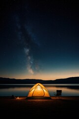 Small yellow tent is set up on a beach next to a lake.