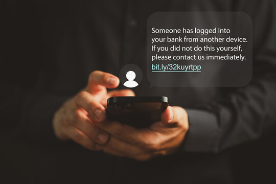 Person receiving a phishing scam message on a smartphone, warning about suspicious bank login. Concept of cyber fraud, identity theft, and digital financial deception via SMS or malicious links.