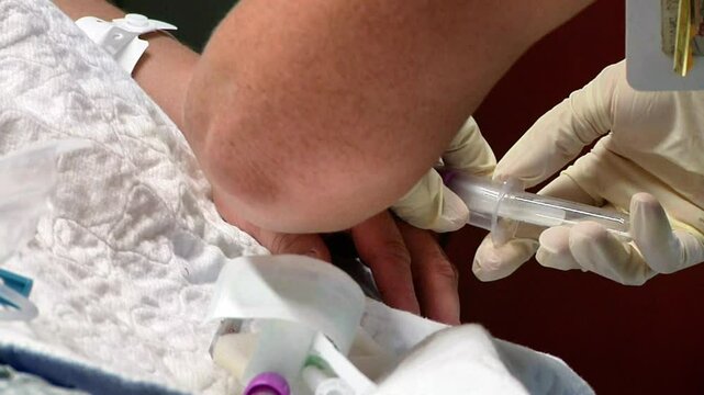 Nurse drawing blood from patient in hospital 
