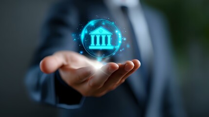 Businessman in dark suit holding glowing blue hologram of bank building icon, representing digital banking and financial technology solutions.