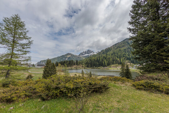vista panoramica sull'ambiente naturale di montagna di Passo Pramollo ed il suo lago, sul confine settentrionale tra Italia ed Austria, di giorno, in primavera, con cielo nuvoloso