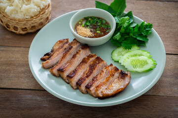 Grilled pork neck and thai spicy dipping sauce on plate served with sticky rice
