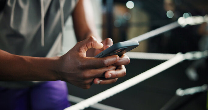 Fitness, man hands and phone in boxing ring for contact, training schedule or typing message on break. Boxer, rest and mobile at gym for social media, status update and online post on exercise forum - Powered by Adobe