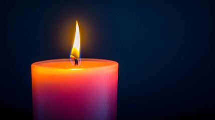 Glowing candle flame in dark ambiance with warm orange glow