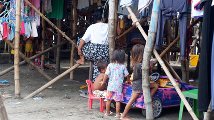 Badjao family spends their time in the basement of stilt houses along the cluttered seashore of the...