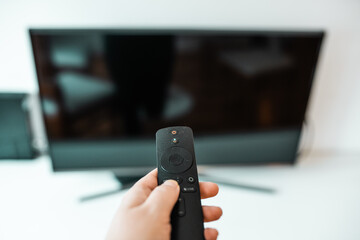Hand with remote control. Streaming services and watching TV concept.