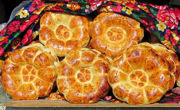 Traditional round Kyrgyz bread, close-up, golden crust, ethnic cuisine, Central Asian food, baked goods, cultural tradition, circular shape, flatbread, texture detail, local bakery, authentic food.
