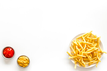Fast food symbol. French fries on plate on white table top-down copy space