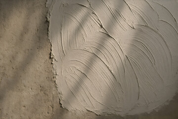 Freshly applied plaster patch on wall surface showing smoothing texture in repair finishing stage