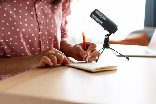 Woman Taking Notes During Podcast Recording Session - Powered by Adobe