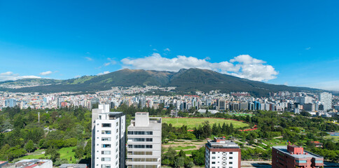  view of La Carolina Park surrounded by modern buildings in the northern part of Quito with the Rucu Pichincha volcano in the background