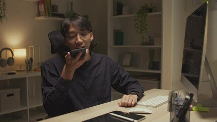 Modern man freelancer using AI voice assistant to make hands-free searches while working remotely, boosting productivity, embracing smart technology in a flexible work environment