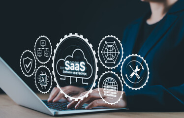 SaaS Concept. Software as a Service Technology. Person using laptop with cloud and gear icon SaaS,...