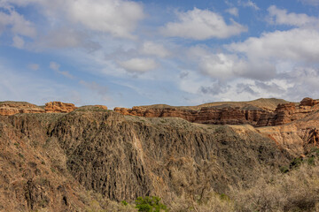 Stunning view of Charyn Canyon cliffs under a partly cloudy sky