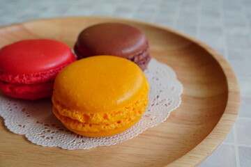 赤、オレンジ、茶色のマカロンが並べられた、美味しそうなデザートのクローズアップ