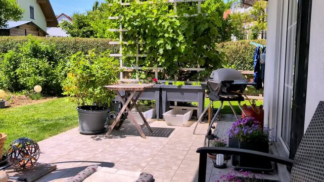 Garden Terrace with Grill and Plants on a Sunny Spirng Day.