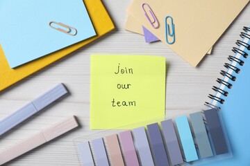 Paper note with phrase Join Our Team and stationery on wooden table, flat lay