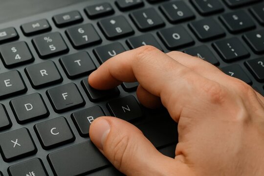  A person's hand is pressing a button on a computer keyboard