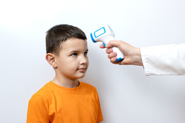 The child's body temperature is measured with a non-contact thermometer.