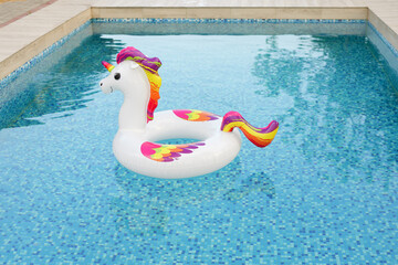 
A cheerful inflatable unicorn float gently rests in a sparkling blue swimming pool, ready for...