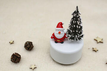 A charming miniature santa claus figurine and snow-dusted christmas tree on a soft background