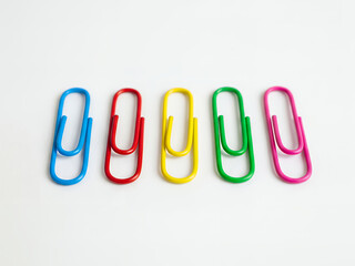 A Collection of Colorful Paper Clips Arranged in a Row on a White Background