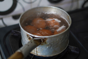 The process of boiling eggs in a pan with boiling water