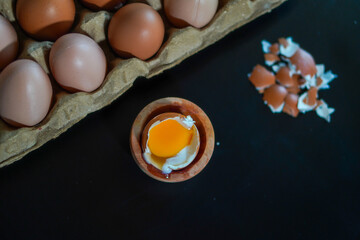 One half boiled egg complete with several whole eggs on top of the egg carpet and egg shells
