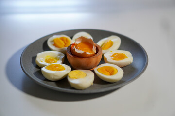 Various degrees of doneness of boiled eggs on a white background